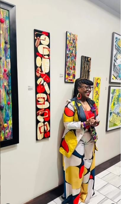 Annika Jones of Artful Hues featured at an art gallery exhibition, sharing her creative vision and wearable art pieces with collectors and art enthusiasts.