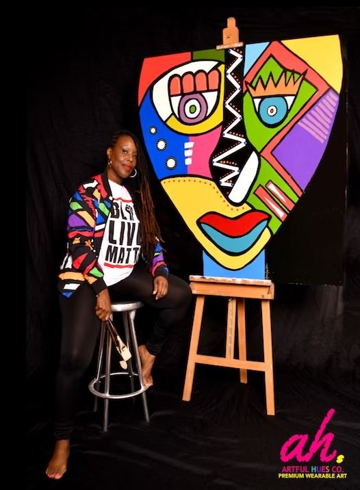 Annika Jones, founder of Artful Hues, pictured with her original artwork representing her vision of premium wearable art that blends creativity, color, and personal expression.
