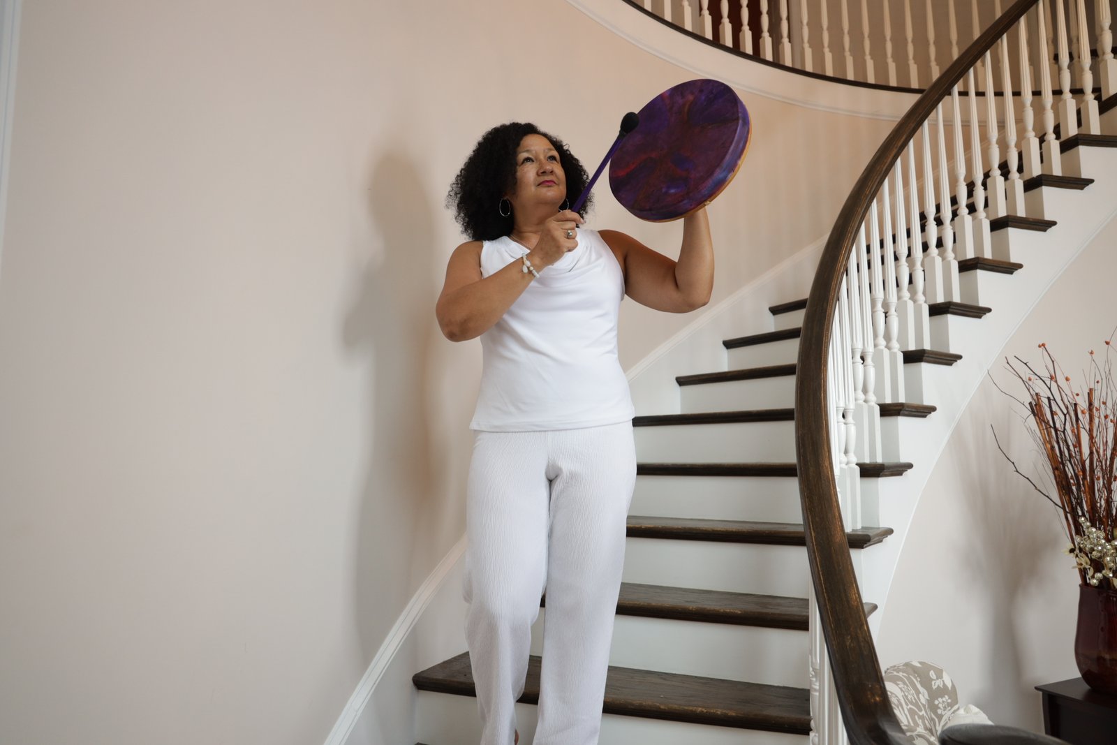 Linda K. Harmony using a ceremonial drum to clear stagnant energy from a residential space as part of a professional energetic space clearing session.