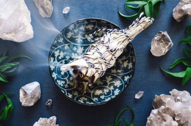 Sage and crystals used for energetic space clearing and home energy cleansing to support balance, clarity, and harmony.